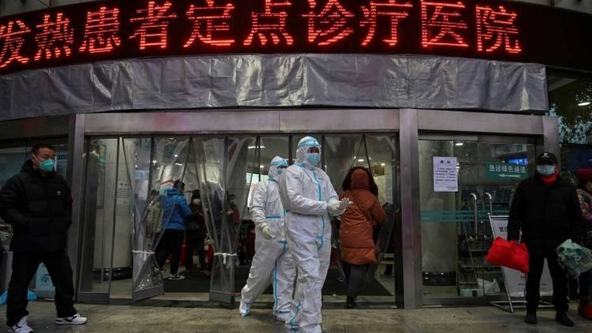 Personnel médical en combinaison de protection devant l'hôpital de la Croix-Rouge, le samedi 25 janvier 2020 à Wuhan, épicentre du nouveau coronavirus en Chine. 
