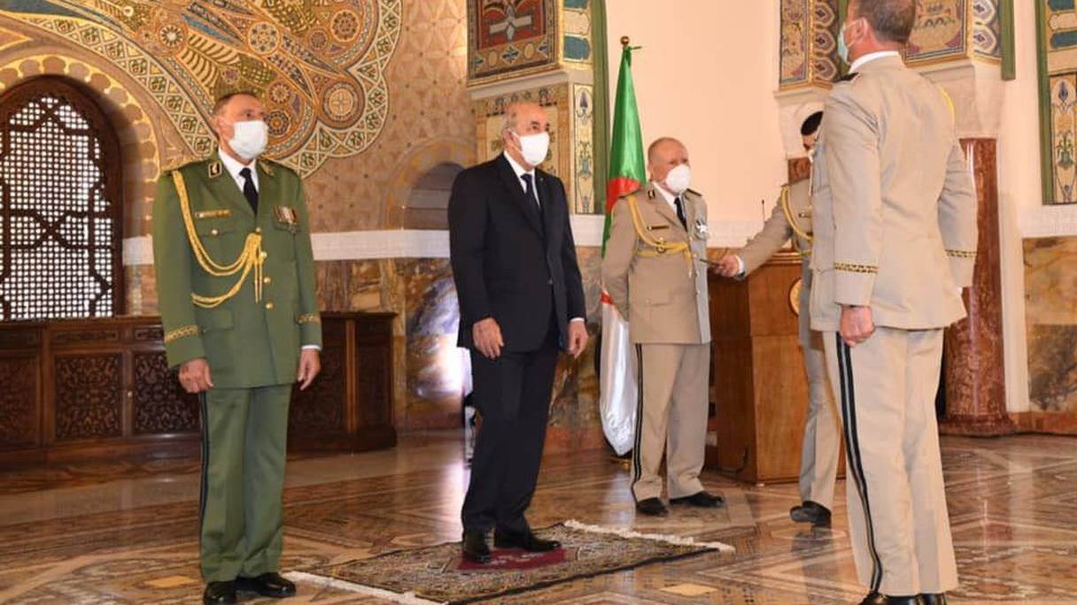 Le président algérien Abdelmadjid Tebboune, entouré du chef d'état major de l'armée algérienne, le général Saïd Chengriha, et du commandant de la garde présidentielle, le général Benali Benali. 

