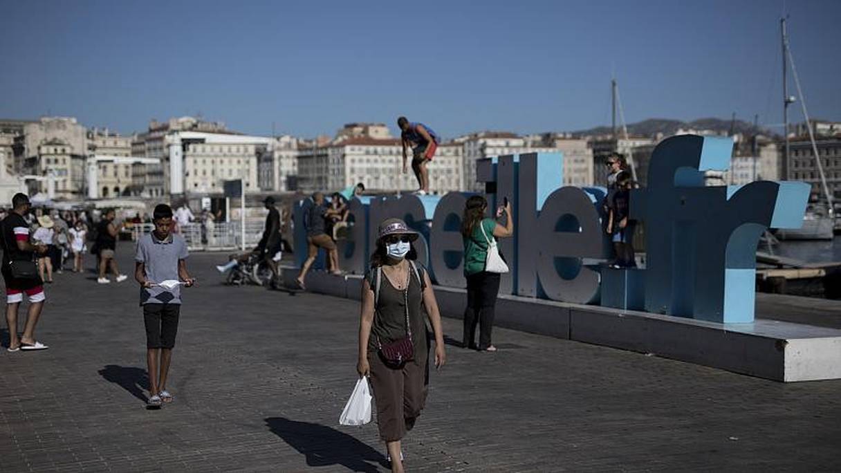 Une femme masquée marche le long du Vieux Port de Marseille, le 7 août 2020. 
