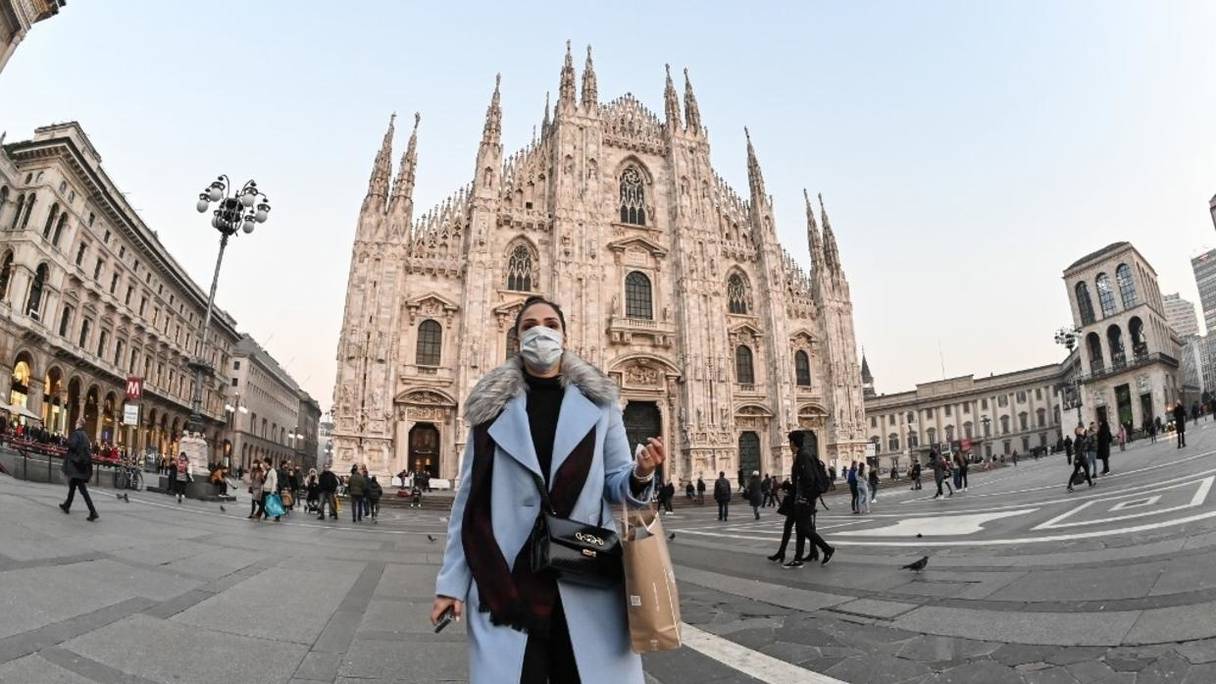 En Italie, dans le centre de Milan, sur la Piazza del Duomo, une femme porte un masque de protection contre le coronavirus, le 24 février 2020.
