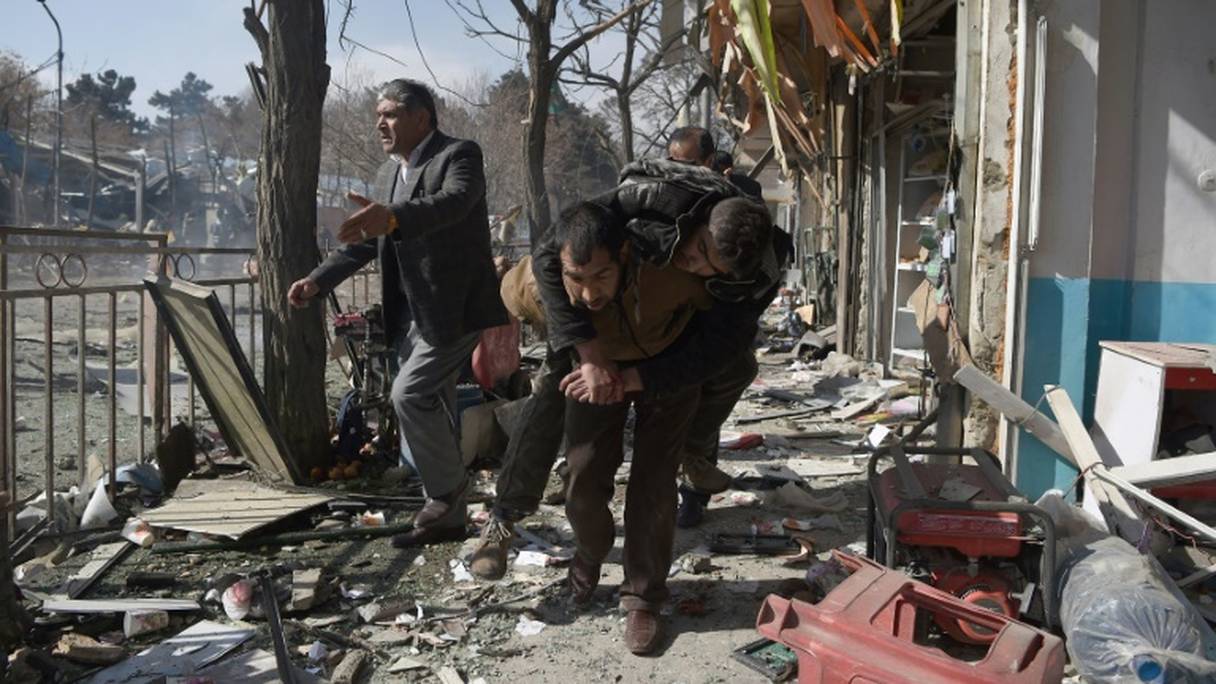 Des volontaires afghans viennent en aide aux victimes de l'explosion d'une ambulance piégée à Kaboul, le 27 janvier 2018.
