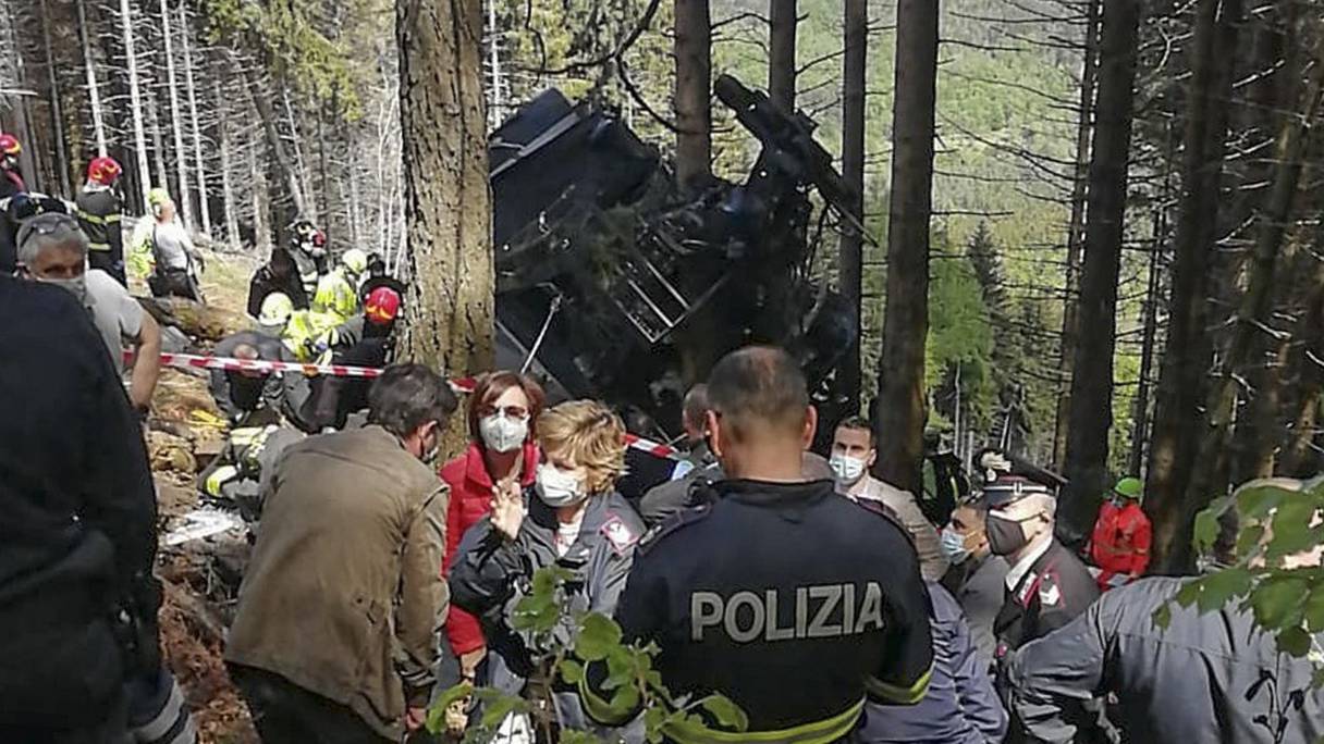 Une photo de la police d'État italienne (Polizia di Stato) montre des policiers et des sauveteurs près d'un téléphérique qui s'est écrasé au sol dans la station balnéaire de Stresa, sur les rives du lac Majeur dans la région du Piémont, le 23 mai 2021. 
