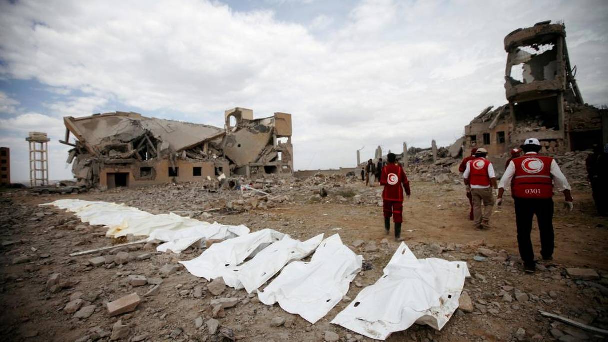 Des médecins du Croissant-Rouge marchent à côté de sacs contenant les corps des victimes des frappes aériennes dans un centre de détention houthi à Dhamar, au Yémen, le 1er septembre 2019.
