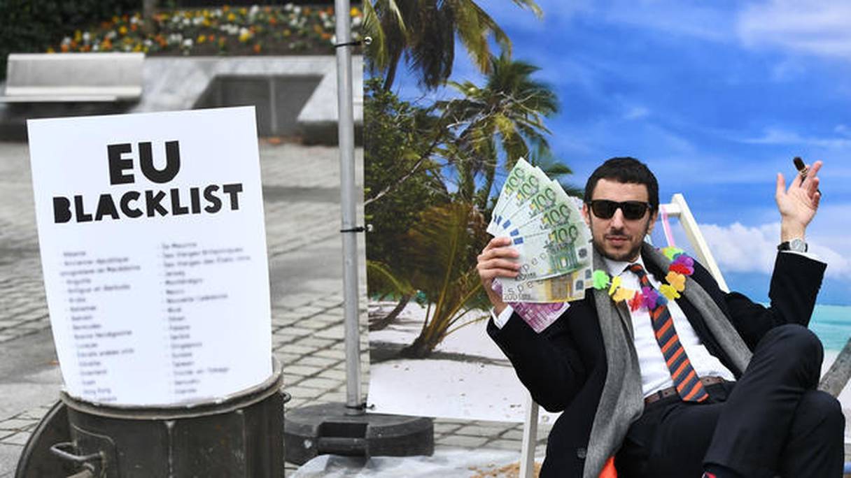 Un activiste d'Oxfam organise un jeu de rue satirique, imitant une personne riche cachant son argent dans un paradis fiscal, le 5 décembre 2017.
