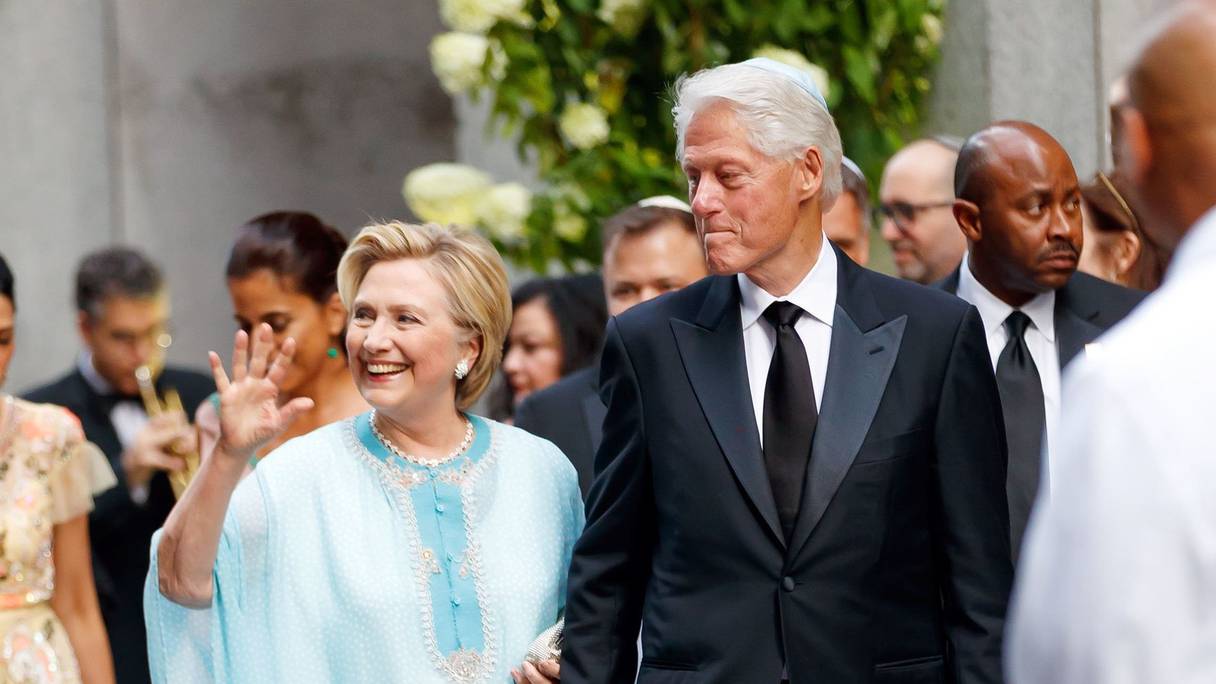 Hillary Clinton en caftan, aux côtés de son époux, Bill Clinton. En 2017, lors du mariage de Sophie Lasry et Alexander Swieca, à New York.
