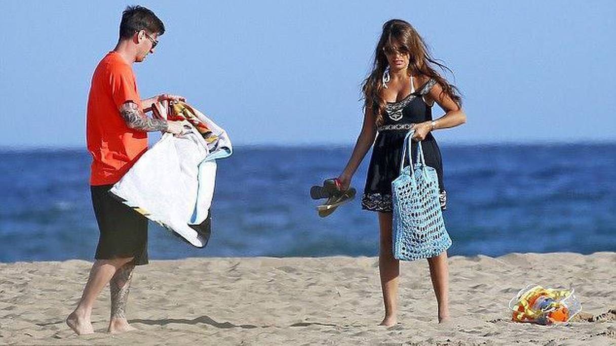 Messi sur une plage avec son épouse.
