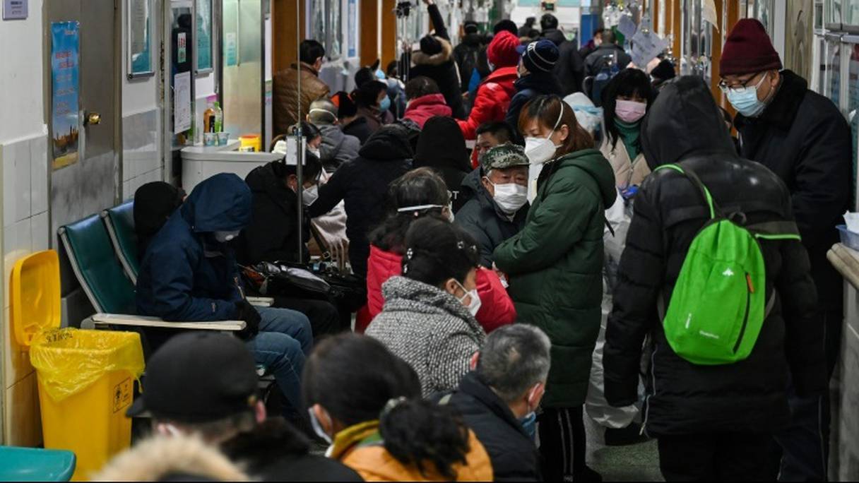 Des malades attendent dans un couloir d'être pris en charge par des médecins à l'hôpital de la Croix-Rouge de Wuhan, le 25 janvier 2020 en Chine.
