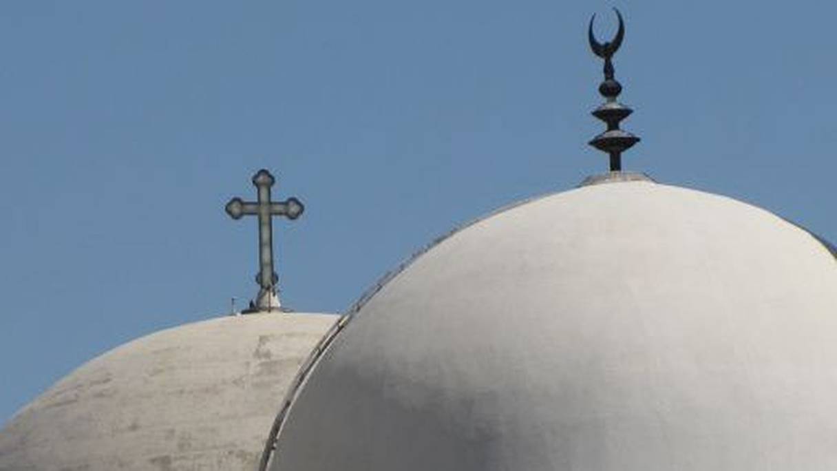 Dômes de deux édifices religieux, l'un surmonté d'une croix, symbole du christianisme, l'autre d'un croissant, symbole de l'islam. 
