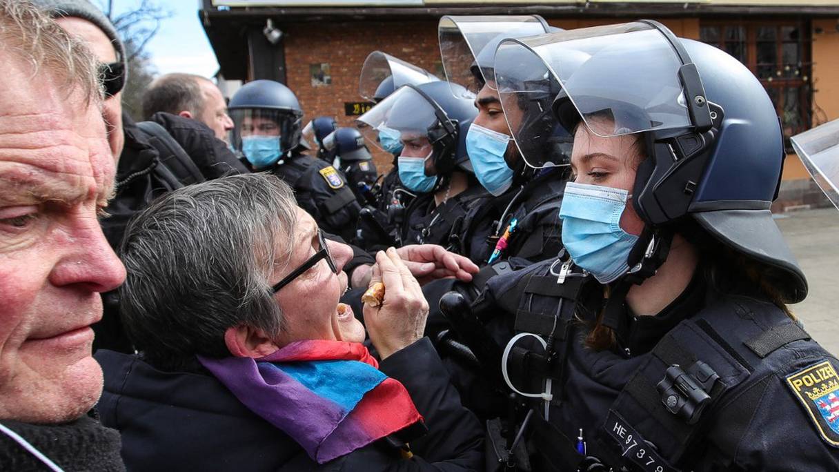 La police tente de repousser des manifestants qui exigent le respect des droits fondamentaux et la fin des mesures restrictives contre le coronavirus à Kassel, dans le centre de l'Allemagne, le 20 mars 2021. 
