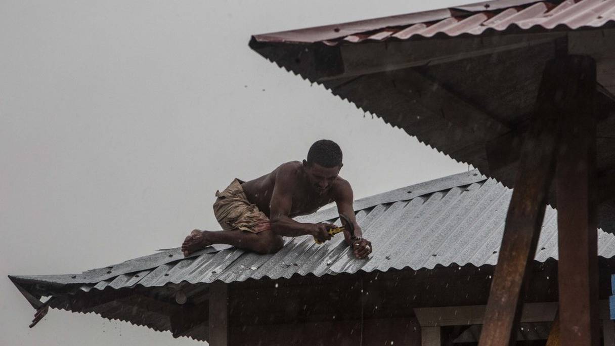 Un homme consolide le toit de sa maison à Bilwi (Puerto Cabezas) au Nicaragua, le 16 novembre 2020, alors que l'ouragan Iota s'approche de la frontière entre le Nicaragua et le Honduras. 
