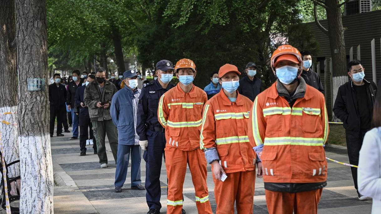 Des gens font la queue sur un site de test du coronavirus Covid-19 à Pékin le 29 avril 2022. 
