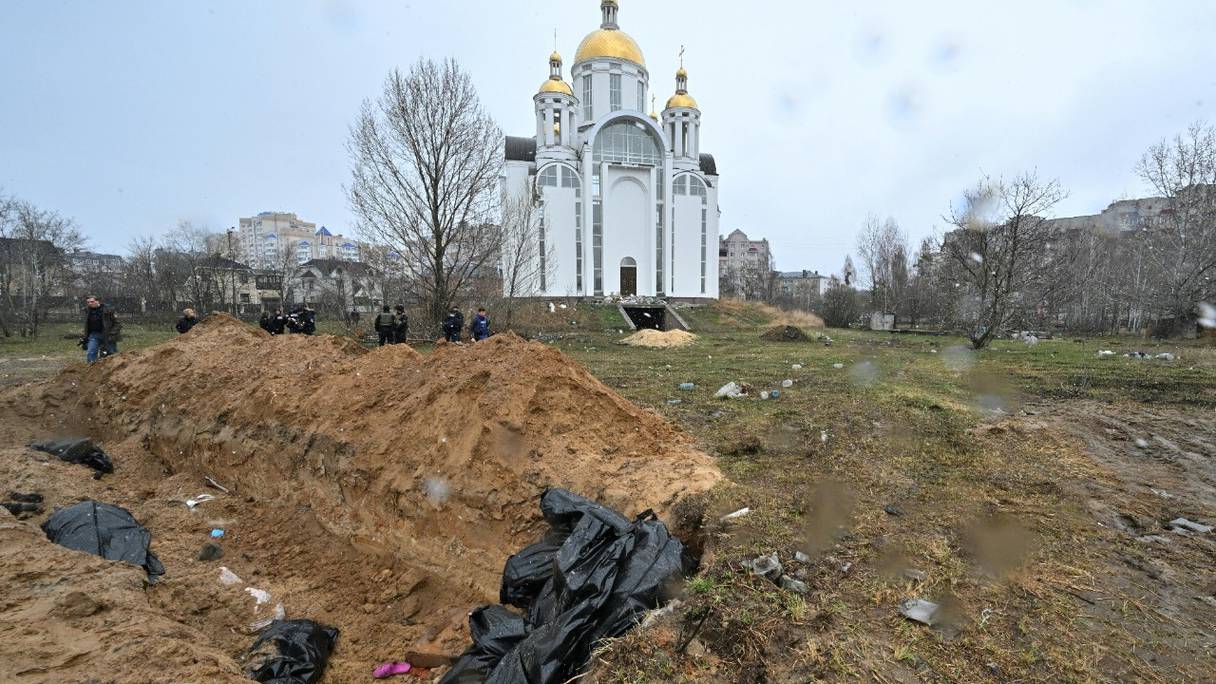 Une fosse commune, derrière une église dans la ville de Boutcha, au nord-ouest de la capitale ukrainienne Kiev, le 3 avril 2022. L'Ukraine et les pays occidentaux ont accusé les troupes russes de crimes de guerre après la découverte de charniers près de Kiev.
