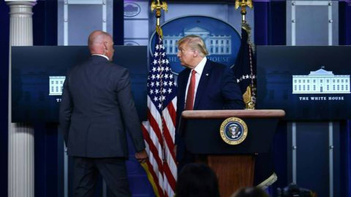 Le président américain Donald Trump évacué en pleine conférence de presse par un membre du "Secret Service" le 10 août 2020, après des tirs devant la Maison Blanche. 
