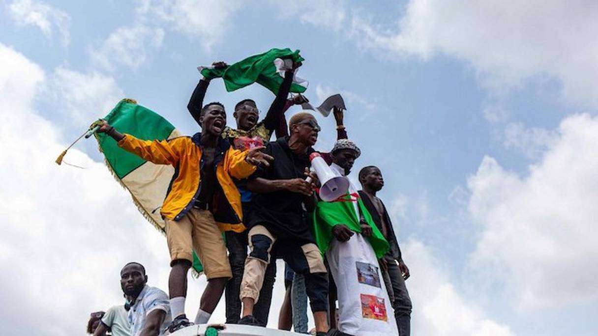 De jeunes Nigérians agitant le drapeau de leur pays, lors de manifestations contre la police.
