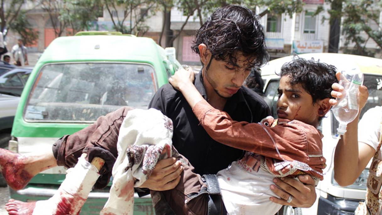 Un enfant est porté à l'écart des combats à Taez, au Yémen. 
