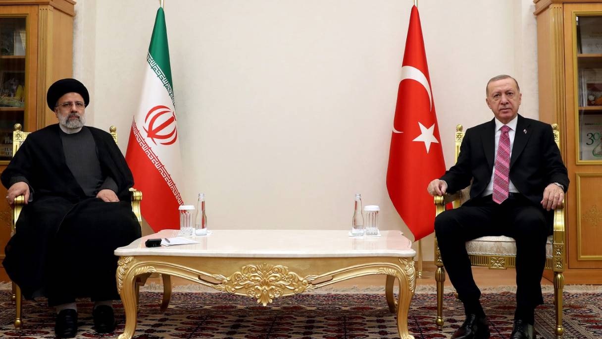 Le président turc Recep Tayyip Erdogan (à droite) pose avec le président iranien Ebrahim Raïssi, au 15e sommet de l'Organisation de coopération économique à Achgabat, au Turkménistan, le 28 novembre 2021.

