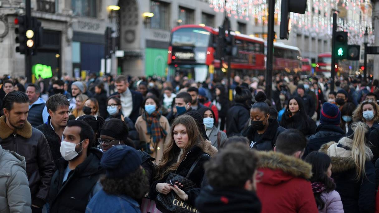 Une foule compacte, pour certains masqués, se presse le long d'Oxford Street dans le centre de Londres, le 4 décembre 2021.
