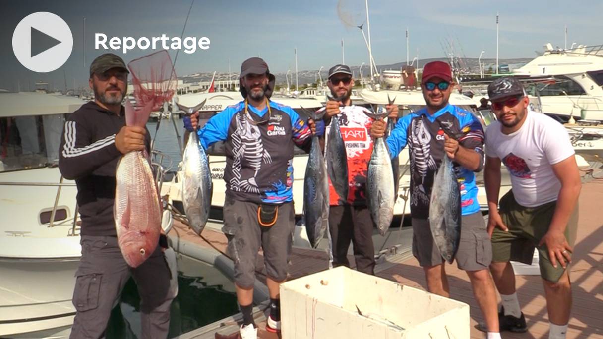 Des pêcheurs montrent fièrement leur prise, lors de la compétition de pêche libre de plaisance qui a eu lieu les 16 et 17 avril 2022 au port de Tanger. 
