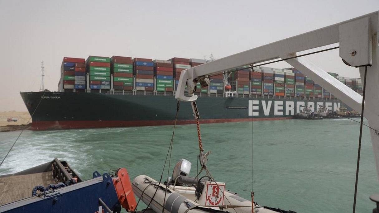 Des remorqueurs essaient de libérer le cargo taïwanais Evergreen, de 400 mètres (1300 pieds) de long et 59 mètres de large, logé sur le côté et gênant tout le trafic sur la voie navigable du canal de Suez, en Egypte (photo de l'Autorité du canal de Suez, le 25 mars 2021).
