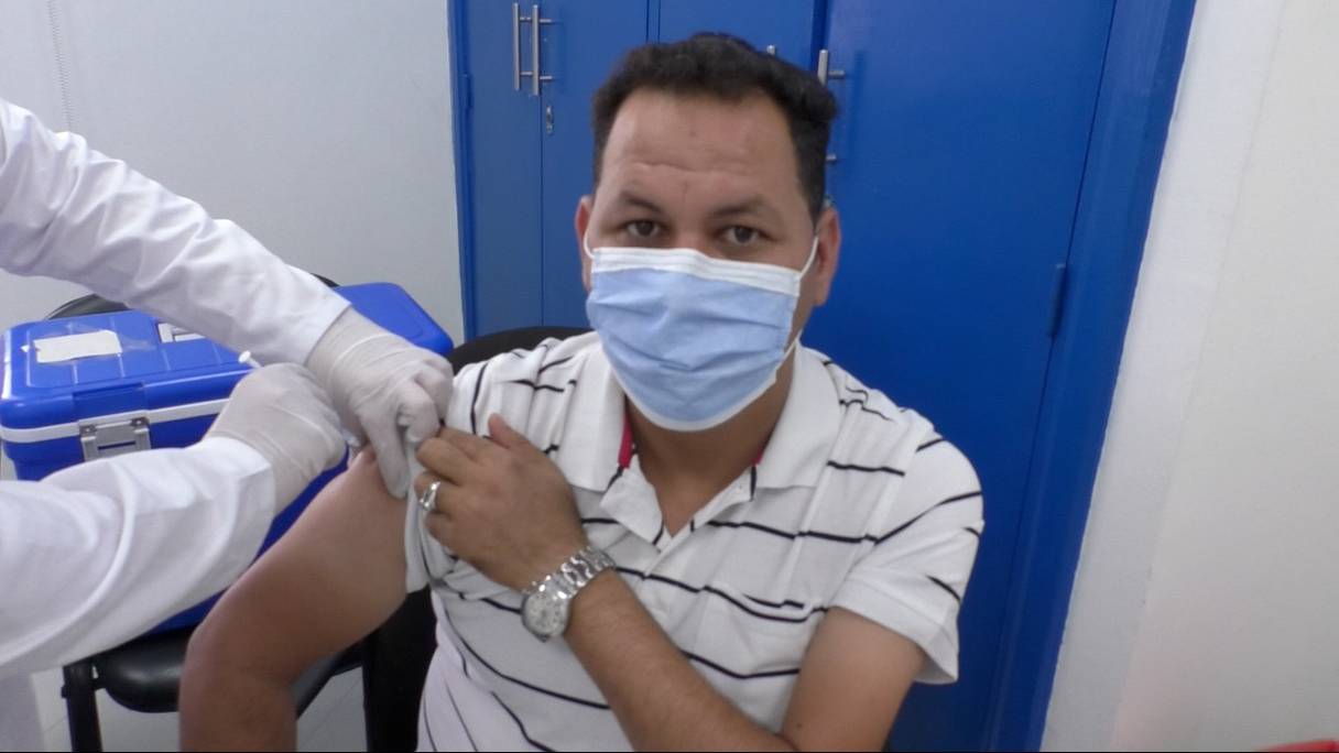 Un homme retrousse la manche de son T.shirt pour recevoir l'injection d'un vaccin anti-Covid-19, à Sidi Hajjaj (région de Casablanca-Settat). 
