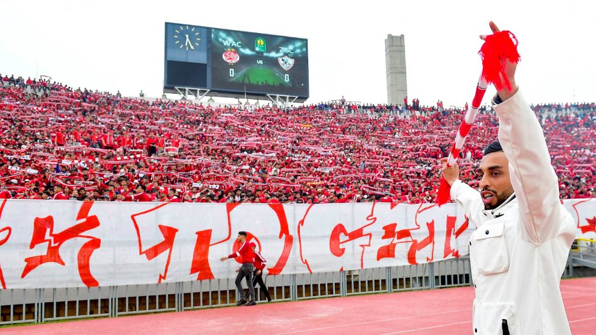 Des supporters brandissent des écharpes lors du match de la Ligue des champions de la CAF entre le Wydad de Casablanca et le Zamalek du Caire au stade Mohammed V, à Casablanca, le 26 février 2022, après la réouverture des terrains de football au Maroc.
