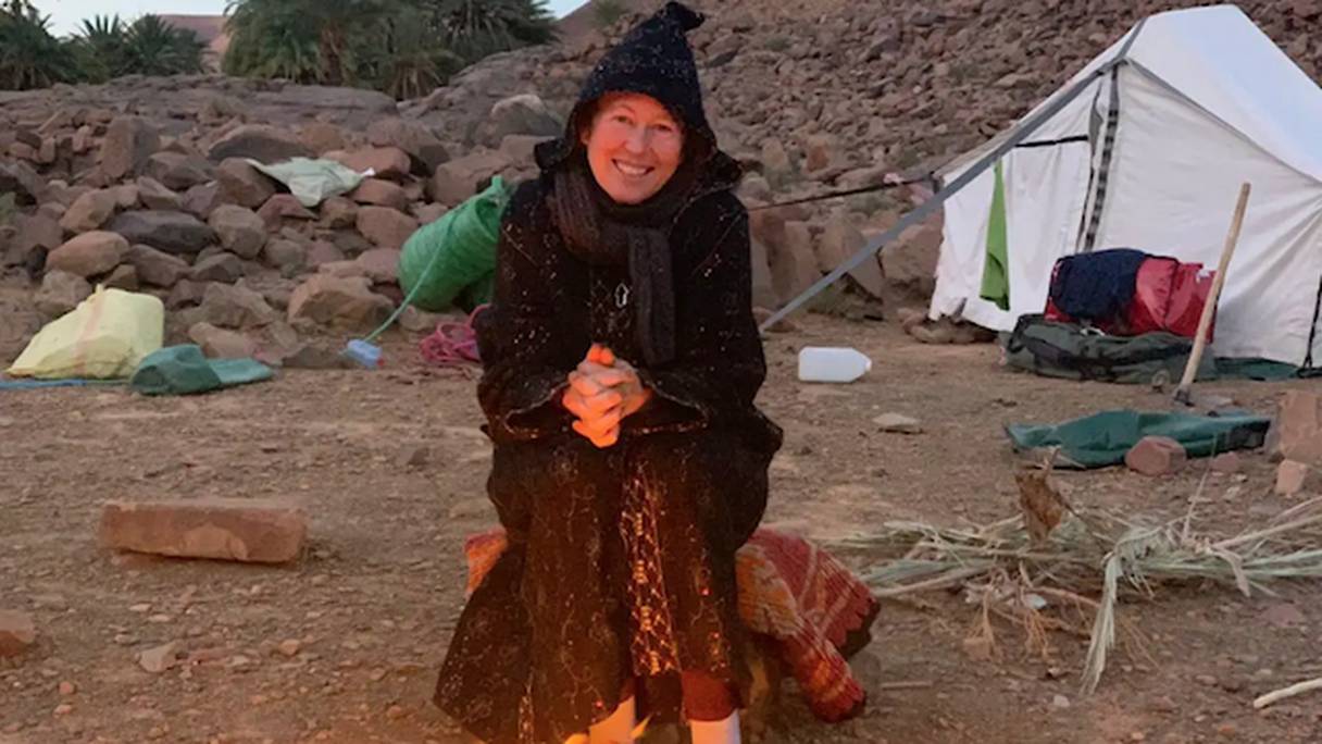 Alice Morrison se réchauffe devant un feu de camp. 
