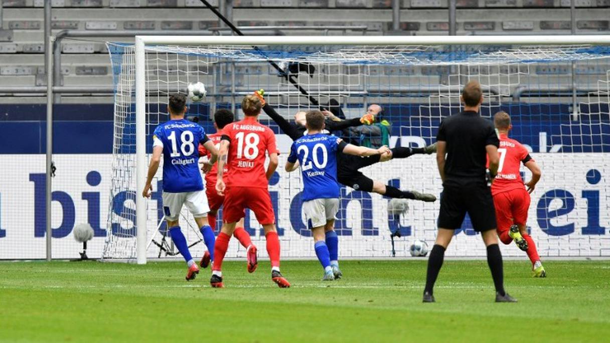 Le gardien de Schalke ne peut arrêter le coup franc tiré par le milieu d'Augsbourg, Eduard Löwen, lors du match de Bundesliga à Gelsenkirchen, le 24 mai 2020
