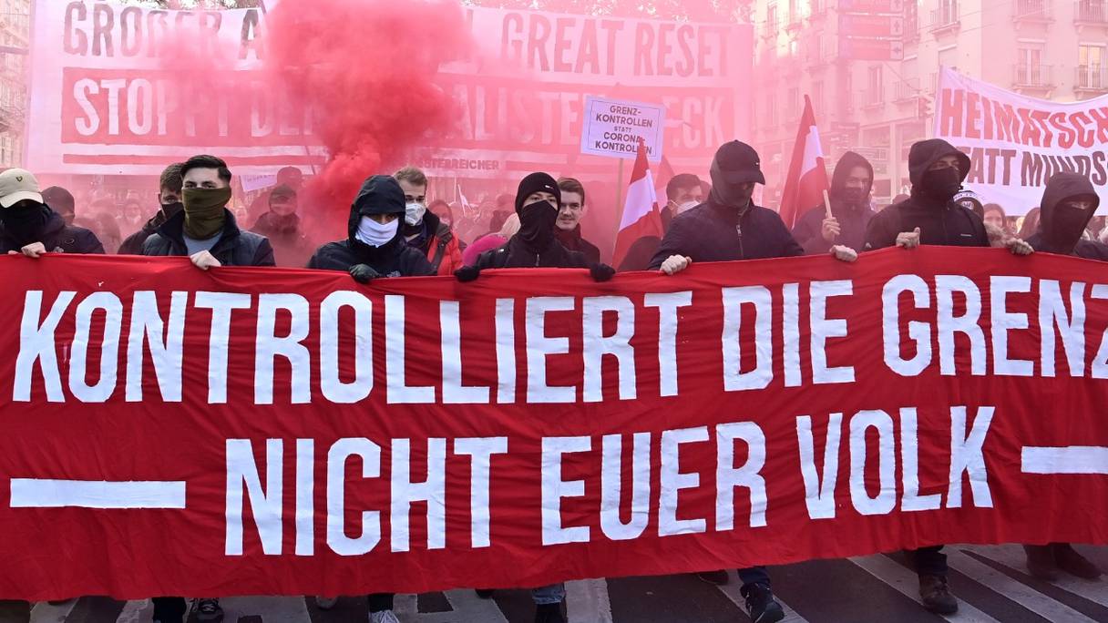 Des manifestants tiennent une banderole sur laquelle est écrit "Contrôlez les frontières-pas votre peuple" lors d'un rassemblement organisé par un parti d'extrême-droite contre les mesures prises pour enrayer la pandémie, à Vienne, en Autriche, le 20 novembre 2021.
