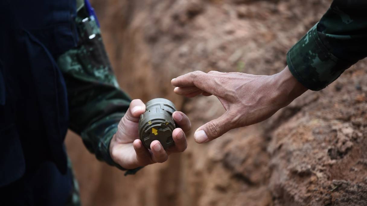 Un soldat manipule une mine antipersonnel avant une détonation contrôlée lors d'une cérémonie de destruction de mines antipersonnel, ici en Thaïlande, le 6 août 2019.
