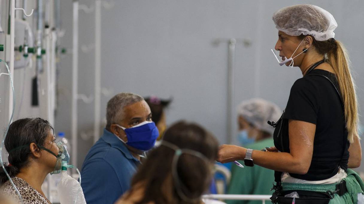 La chirurgienne brésilienne Marise Gomes (à droite), s'occupe de patients d'un hôpital installé dans une salle de sport à Santo Andre, dans l'Etat de Sao Paulo, au Brésil, le 26 mars 2021. 
