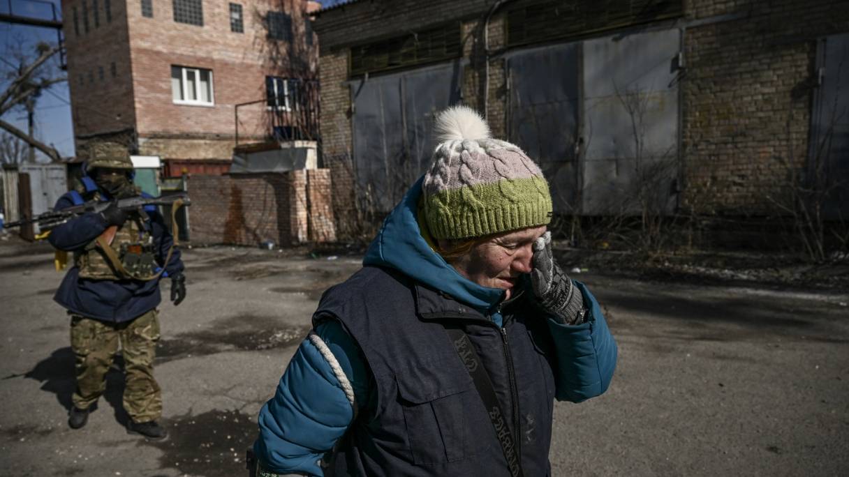 Une femme pleure alors qu'elle évacue la ville d'Irpin, au nord de Kiev, le 10 mars 2022.
