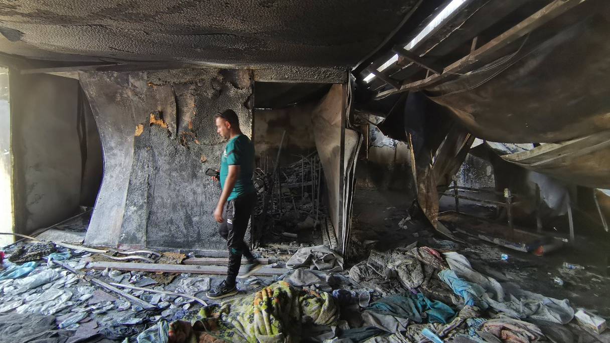 Un homme regarde le service d'isolement des cas de coronavirus, ravagé par les flammes, de l'hôpital d'Al-Hussein après qu'un énorme incendie l'a détruit pendant la nuit dans la ville de Nasiriyah, dans le sud de l'Irak, le 13 juillet 2021.
