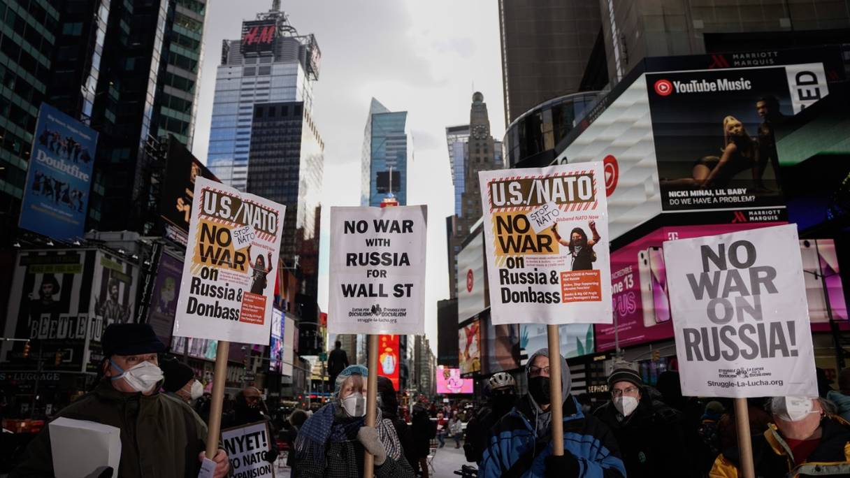 Des manifestants brandissent des pancartes pour protester contre l'implication militaire américaine avec la Russie au sujet de l'Ukraine lors d'un rassemblement à Times Square, dans le centre de New York, le 5 février 2022.
