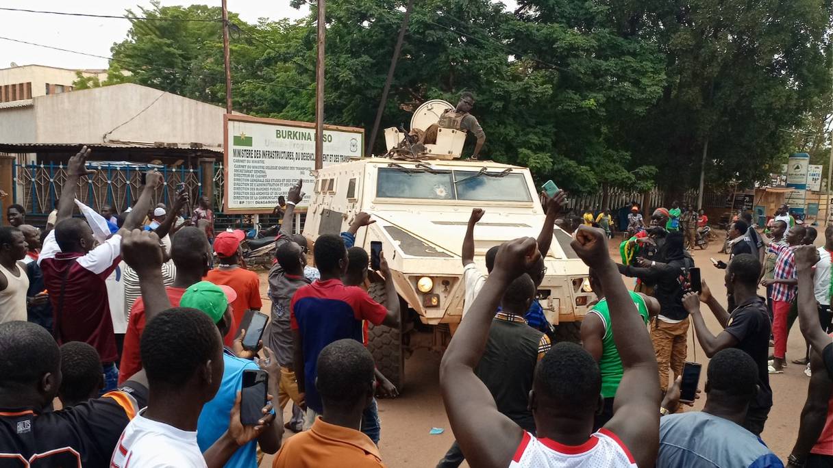 Des manifestants se rassemblent autour d'un véhicule de l'armée burkinabé lors d'une manifestation à Ouagadougou le 2 octobre 2022.
