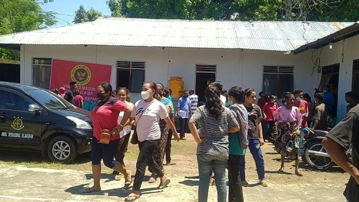 Des villageois se tiennent devant un bâtiment à Maumere dans l'est de Nusa Tenggara sur l'île de Flores le 14 décembre 2021, après un tremblement de terre de magnitude 7,3 au large de la côte est de l'Indonésie.
