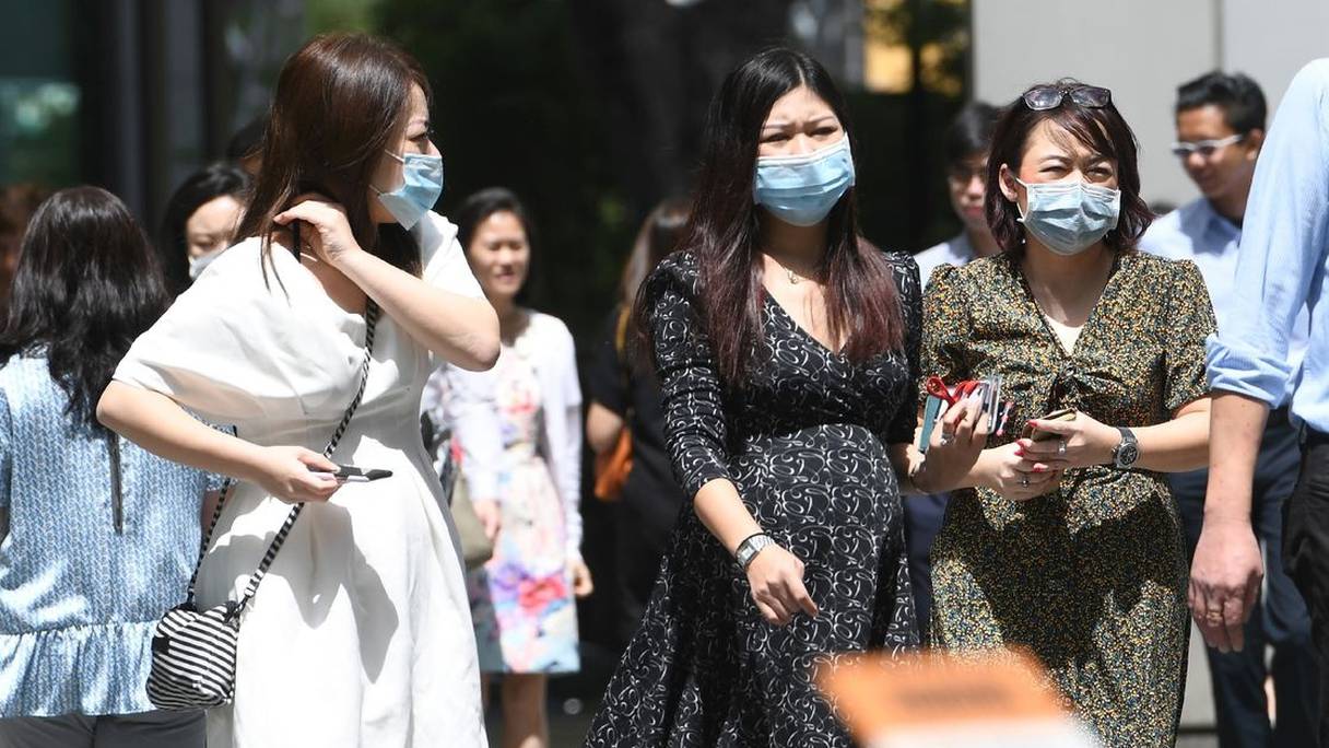 Des habitants portent des masques, par peur de propagation du coronavirus, le 5 février 2020 à Singapour. 
