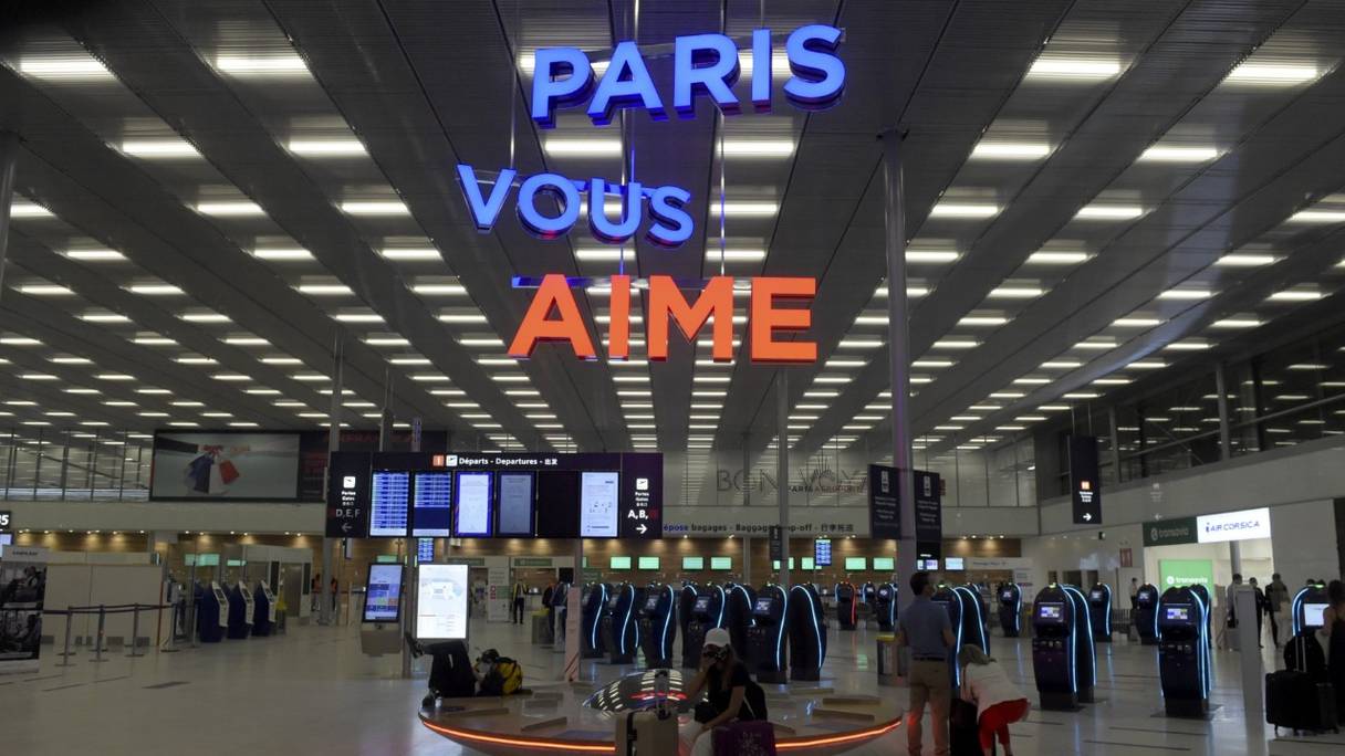 Les passagers attendent devant des bornes d’enregistrement en libre-service au terminal Orly 3 le jour de la réouverture de l’aéroport d’Orly à Paris le 26 juin 2020.
