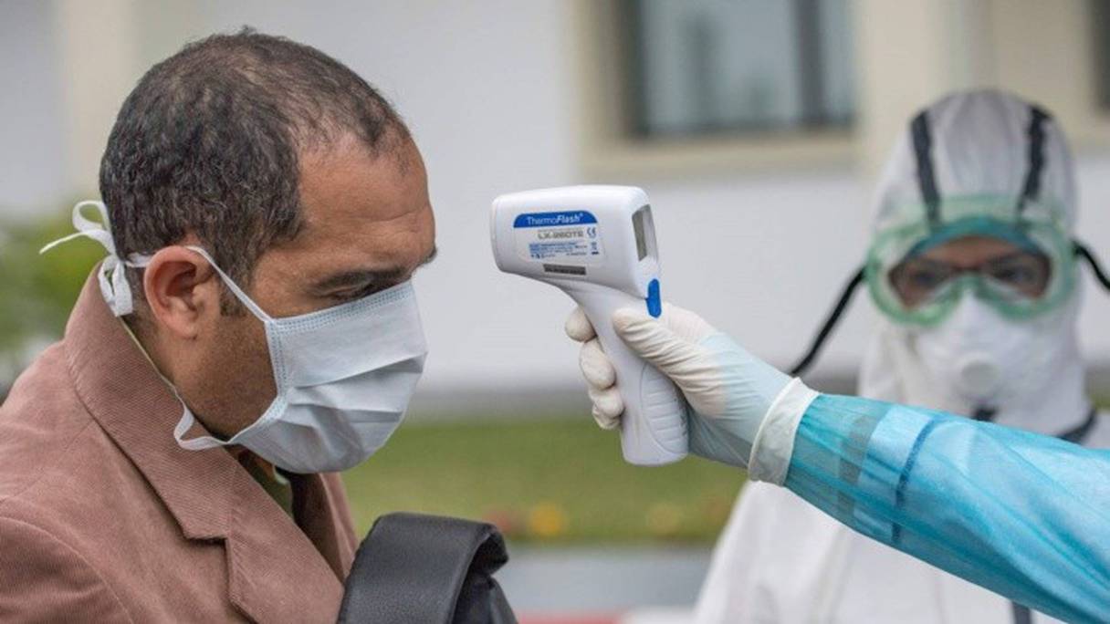Un agent de santé prend la température d'un patient à l'hôpital militaire d'instruction Mohammed V de Rabat.
