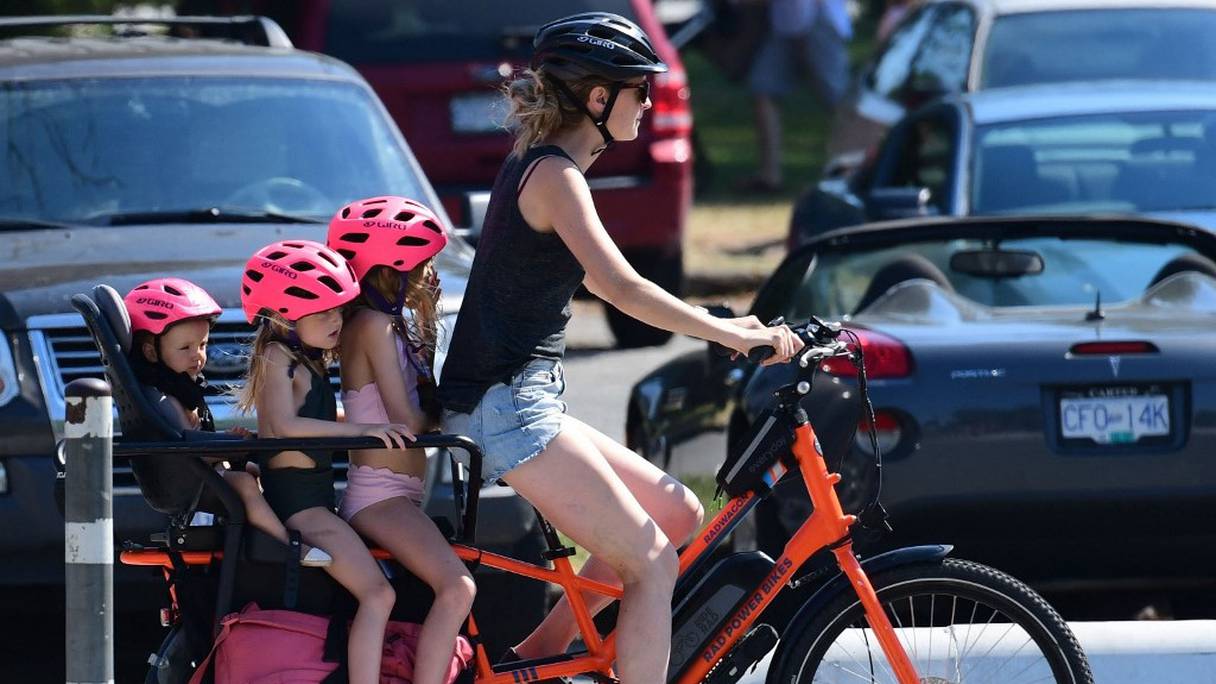 Une femme et trois enfants font une balade à vélo rafraîchissante par une journée caniculaire, à Vancouver, en Colombie-Britannique, le 29 juin 2021.
