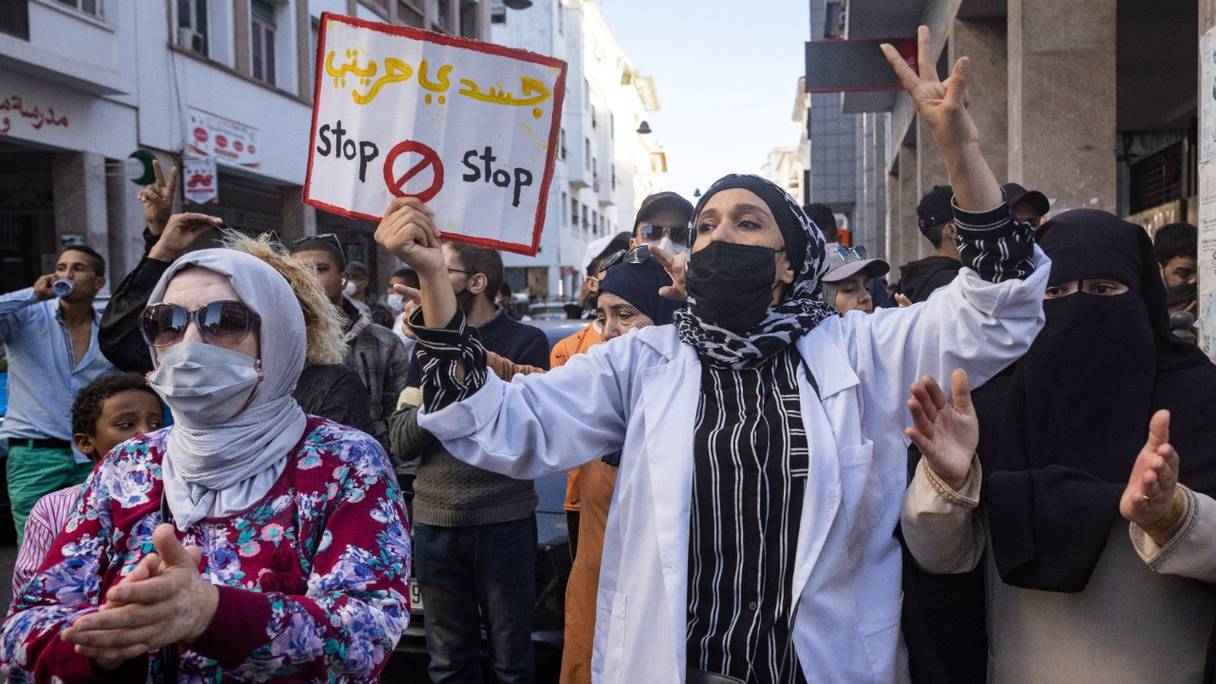 Une manifestante soulevant une pancarte sur laquelle est écrit  en arabe "mon corps, ma liberté lors d'une manifestation dans la ville de Rabat le 31 octobre 2021, contre la décision du gouvernement d'imposer le pass vaccinal. 
 
