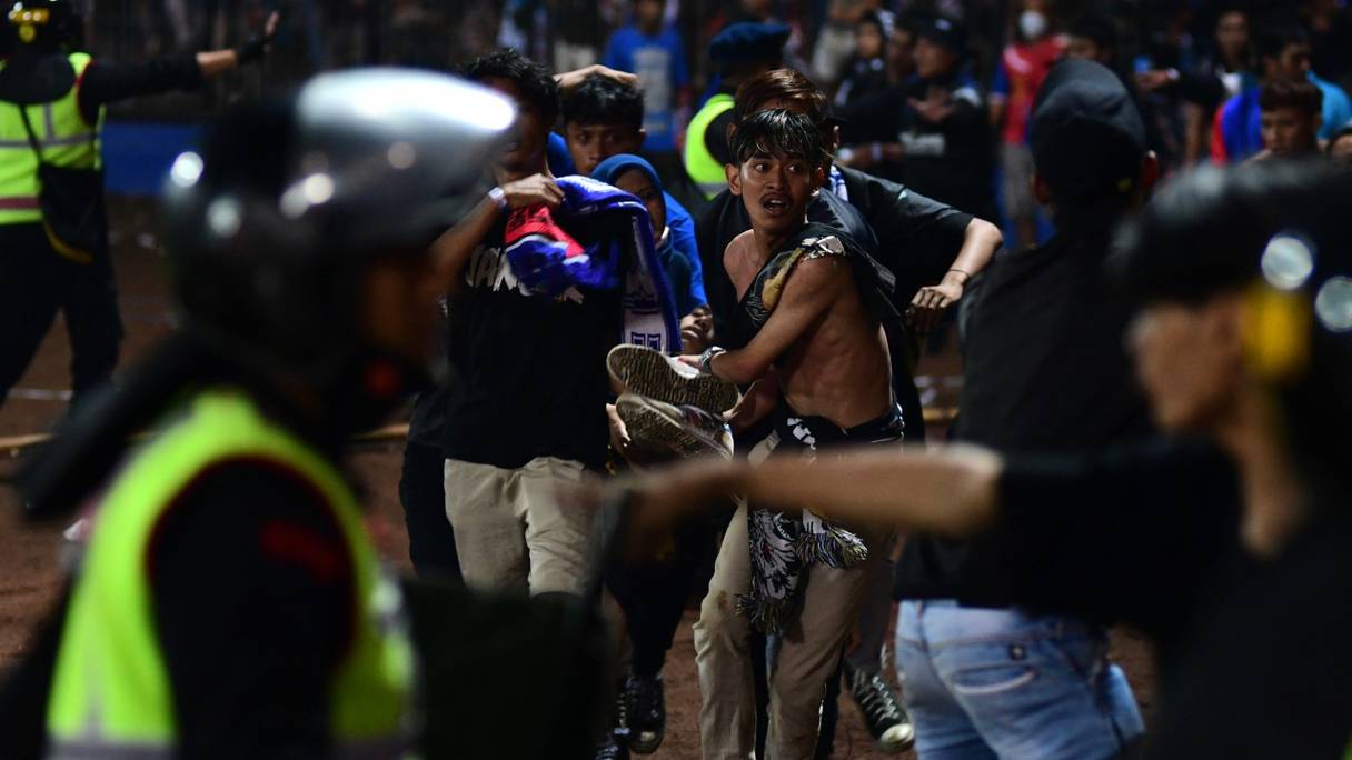 Transport d'un blessé  après un match de football à Malang, en Indonésie. Au moins 127 personnes sont mortes le 1er octobre 2022 dans une bousculade entre supporters dans un stade de football de cette ville à l'est de l'île de Java.
