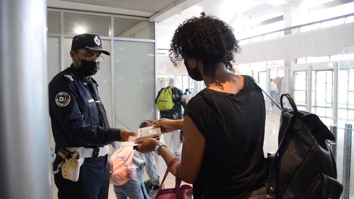 Le Maroc renforce la lutte contre les tests PCR et les pass vaccinaux falsifiés. Ici, un policier contrôle les documents sanitaires des voyageurs à l'aéroport de Casablanca, samedi 4 septembre 2021.
