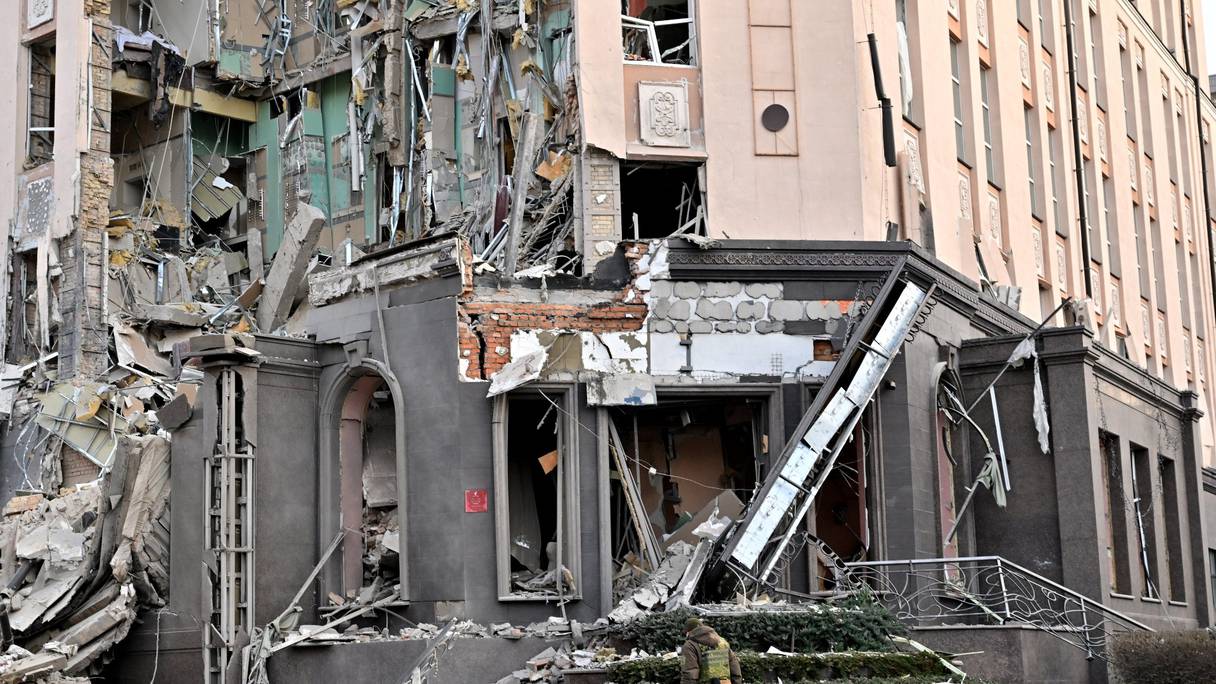 Un militaire marche au pied d'un hôtel, qui a été partiellement détruit par une frappe russe dans le centre de la capitale ukrainienne, Kyiv, le 31 décembre 2022.
