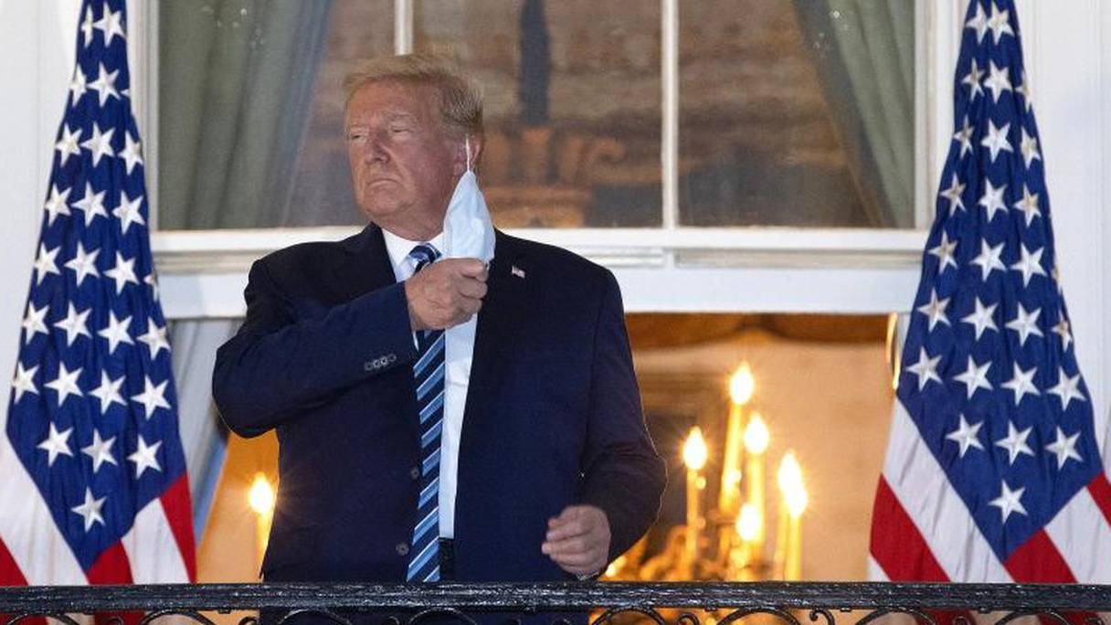 De retour à la Maison Blanche, Donald Trump enlève son masque, le 5 octobre 2020, à Washington.

