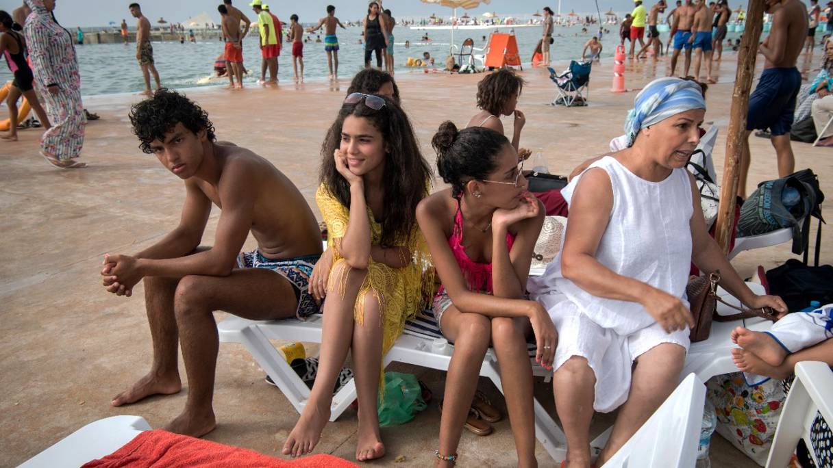 Une famille se rafraîchit au milieu des baigneurs, par temps chaud, dans la nouvelle piscine publique de la capitale, Rabat, le 7 août 2019.
