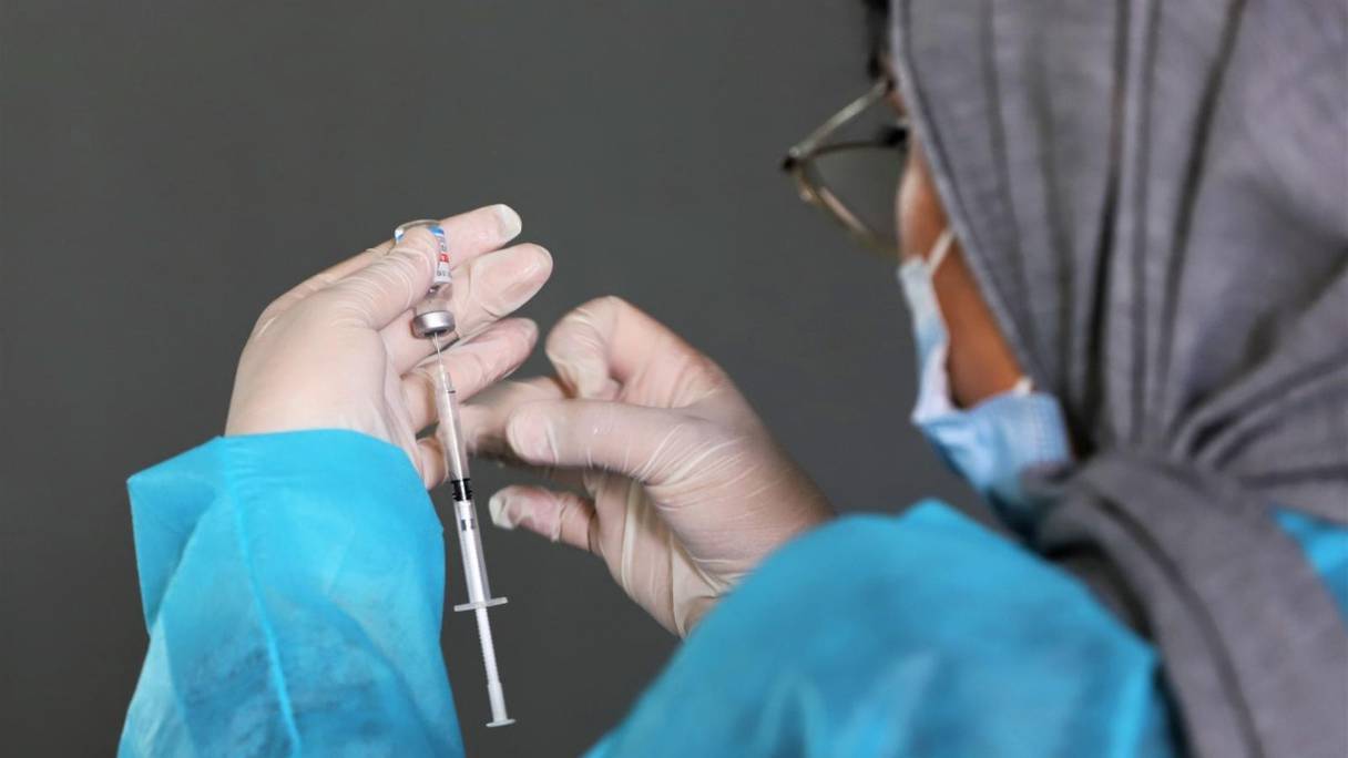 Dans un centre de vaccination à Agadir, une infirmière procède au dosage d'une seringue pour l'administration du vaccin anti-covid, le 29 juillet 2021.
