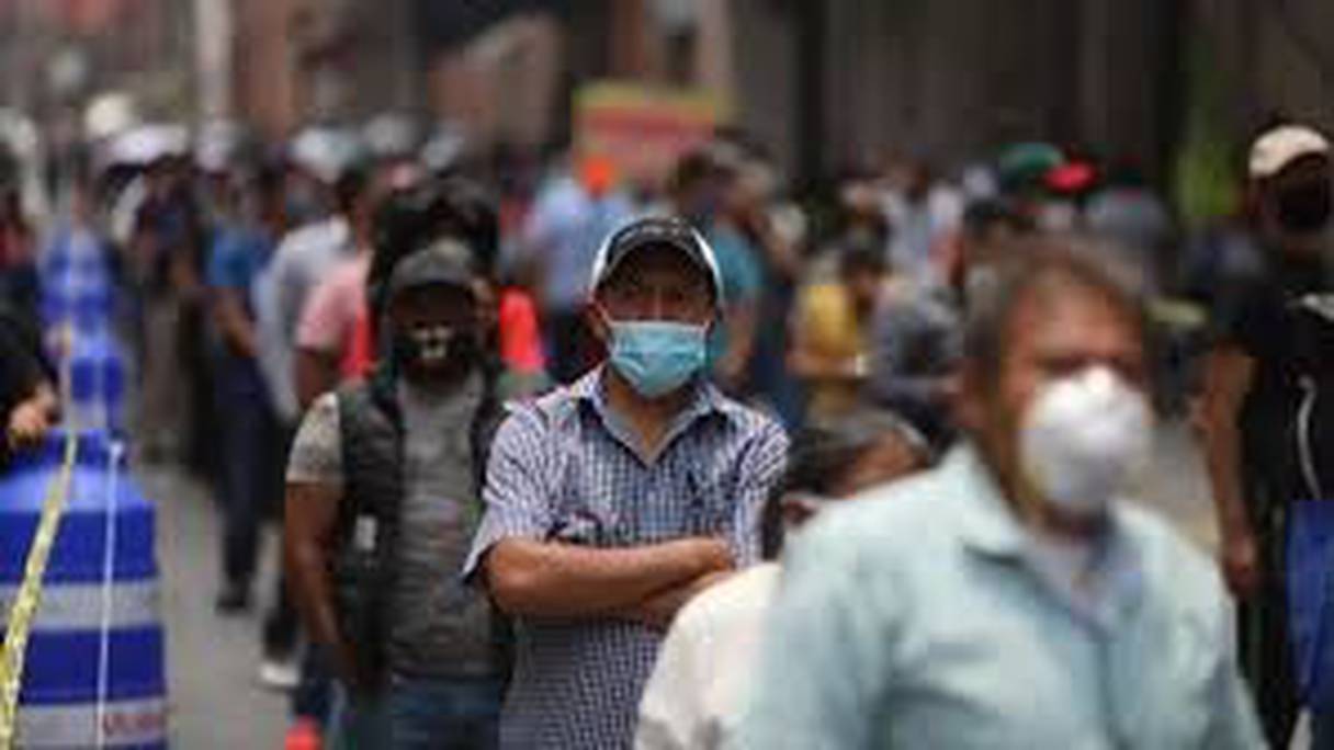Des centaines de Mexicains font la queue devant les commerces réouverts à Mexico, le 6 juillet 2020, alors que l'épidémie de Covid-19 continue de ravager le pays.
