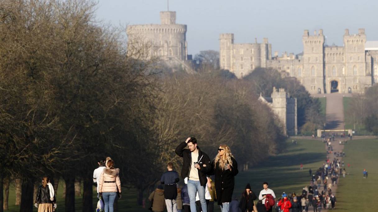 Des personnes se promènent le long de la "Long Walk" au château de Windsor, à l'ouest de Londres, le samedi 9 janvier 2021, dans une Angleterre qui traverse son troisième confinement depuis le début de la pandémie. 
