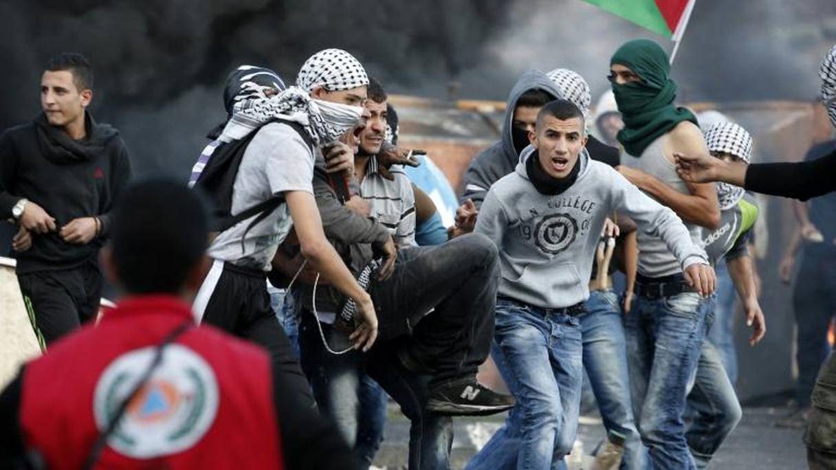 Un Palestinien lanceur de pierre est porté par des camarades après avoir été blessé lors de heurts avec les forces israéliennes près de Ramallah le 9 octobre 2015.
