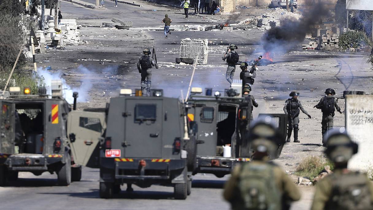 Les forces d'occupation israéliennes tirent des gaz lacrymogènes lors d'affrontements avec des manifestants palestiniens à la suite d'une manifestation en soutien à la mosquée al-Aqsa, le 15 avril 2022.
